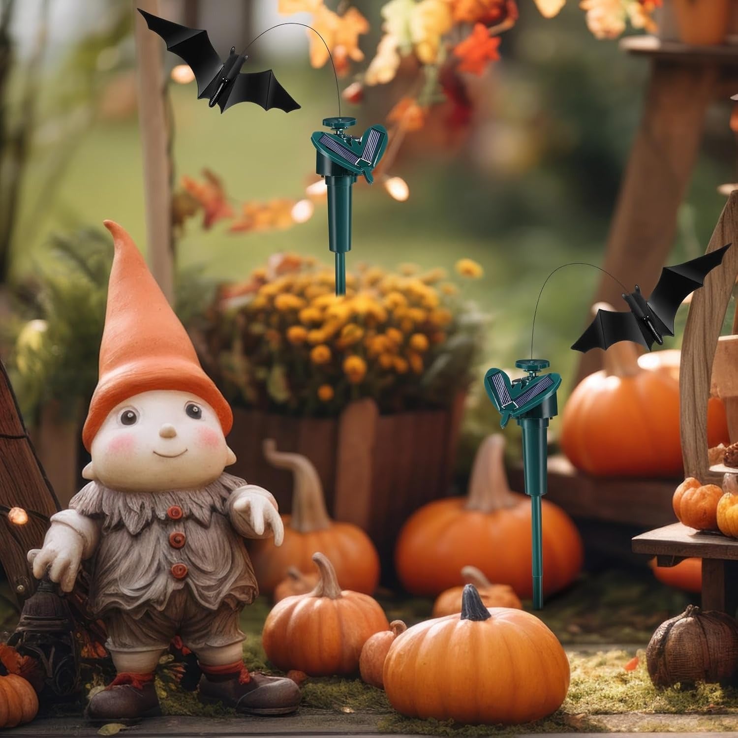 Gnome figurine with pumpkins and Halloween decorations in a garden setting