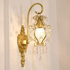 Decorative gold wall sconce with crystal accents on a neutral background