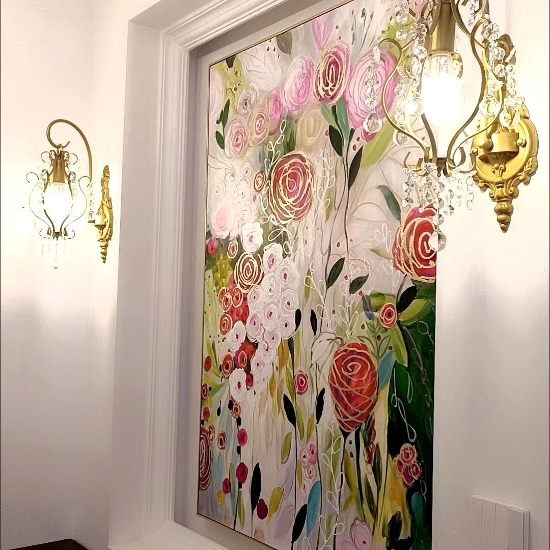 Decorative floral artwork on a wall with ornate wall lights.